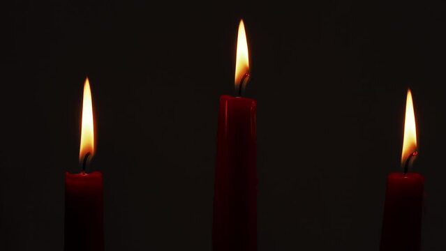 Burning red candles. Burning candles on a dark background.