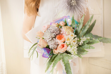 A beautiful delicate bouquet in a woman's hands, close-up
