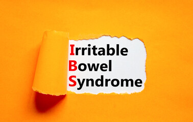 IBS irritable bowel syndrome symbol. Concept words IBS irritable bowel syndrome on white paper on a beautiful orange background. Medical and IBS irritable bowel syndrome concept. Copy space.