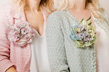 Two women in tweed jackets and brooches in the shape of a flower - obrazy, fototapety, plakaty