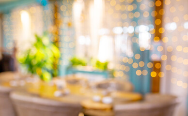 Blurred holiday background. Bokeh background of Christmas garlands. Beautiful New Year's home interior decorations. Festive table in the restaurant.