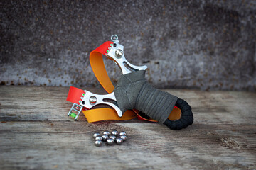 sports slingshot and metal balls on a wooden table, wooden background