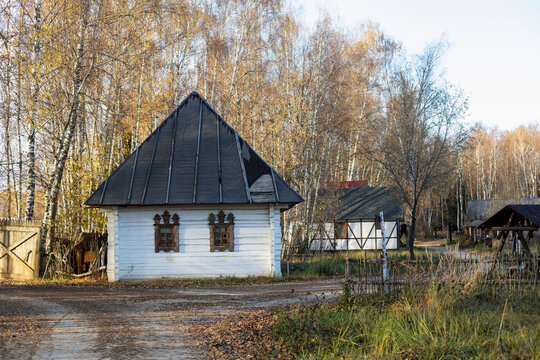 russian white rustic house in autumn with a roof of reeds.