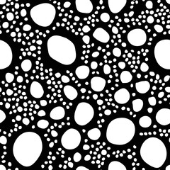 Uneven specks, spots, blobs, splashes seamless pattern. Free hand drawn speckles, flecks, stains or dots of different size texture. Unusual polka dot white on black abstract monochrome background. 