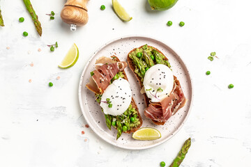 Ketogenic diet meal Poached egg with asparagus spears and prosciutto on a dark background. banner, menu recipe place for text, top view