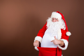 Men's health problems. Funny fat Santa Claus. Brown background.