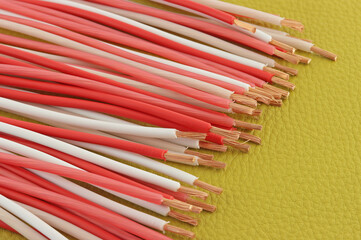 Copper electrical wires in colored insulation on a colored background.