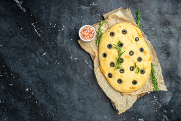 Italian focaccia with rosemary and olives on a dark background. Restaurant menu, dieting, cookbook...