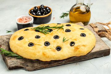 homemade focaccia bread baking with seasonings on a wooden board. banner, menu, recipe place for text, top view