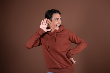 Young attractive guy eavesdrops and gossips.