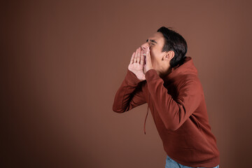 Young attractive guy eavesdrops and gossips.