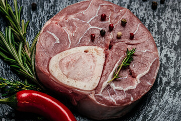 Raw Ossobuko steak marble meat with herbs and spices on dark background. banner, menu, recipe place...