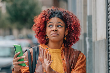 girl or woman in the street with mobile phone and expression of rejection