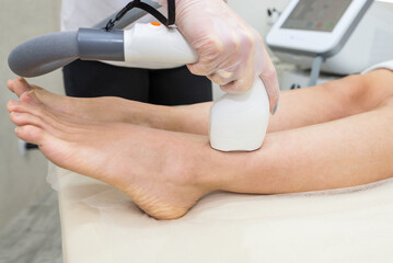 Hair removal on the legs, laser procedure at medical clinic.