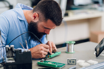 Electronics engineer working in a workshop with tin soldering parts