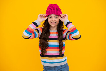 Winter hat. Cold season concept. Winter fashion accessory for children. Teen girl wearing warm knitted hat. Happy teenager, positive and smiling emotions of teen girl.