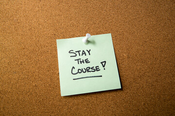 Stay the course note announcement on corkboard