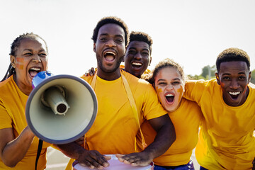 Crazy African football fans celebrating in the crowd watching the game at sport stadium - Soccer supporters shouting for yellow team during world champion event - Focus on senior woman face