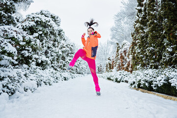 Winter workout, Winter fitness, exercising in cold weather. Sportswoman doing stretching exercises and preparing to run in nature at snowy winter park.