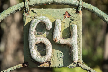 Old retro weathered iron plate with number 64 closeup