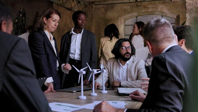 Multiethnic business people working on sustainable renewable energy project inside office - Green alternative electricity concept