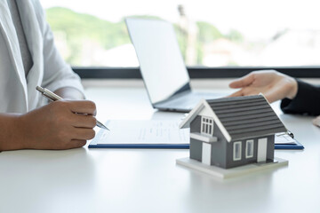 A businesswoman signing a new home purchase or sale from a real estate agent provides tax advice...