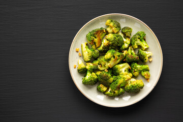 Homemade Pan-Fried Broccoli on a Plate on a black background, top view. Flat lay, overhead, from above. Space for text.
