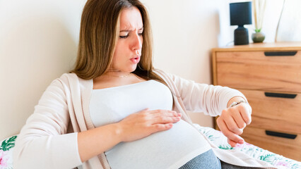 Pregnant time go hospital. Pregnant holding baby belly, woman watching clock. Childbirth time,...