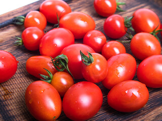 Close-up of red cherry tomatoes on wood, studio shot