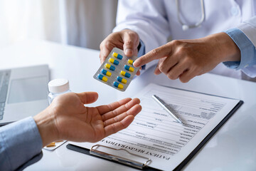doctor or pharmacist advises patients about pills. The doctor prescribes medication sitting at a...