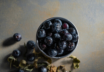 top view of a metal cup with a lot of blueberries.