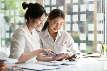 Asian Young colleague business presents and explains and using laptop computer in an office. Teamwork, coworker cooperation, financial marketing team, or corporate business employee concept. © crizzystudio