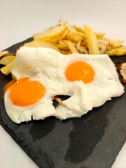 Fried eggs with potatoes served on a plate