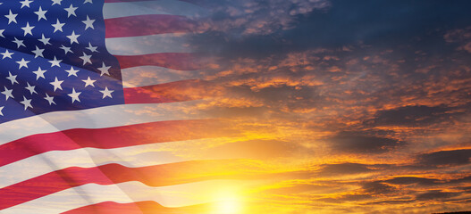 Fototapeta premium United States of America flag on sky at sunset or sunrise background. Independence day, Memorial day, Veterans day. Banner.