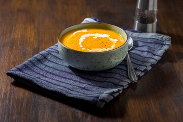 Pumpkin soup strewn with cream, seasoned with pepper
