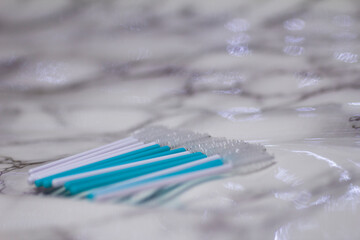 White and blue brushes for eyelashes and eyebrows on a light marble background