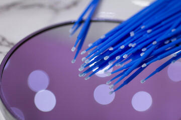 Set of blue microbrushes for eyelashes on a mirror background with bokeh