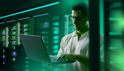 Man programmer. programmer sets up server hardware. Guy programmer in hosting provider building....