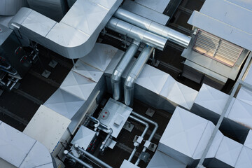 Ducts of the ventilation and air conditioning system on the roof of the building. The photo was taken in natural, soft light. View from above.