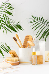 Wooden toothbrushes with natural bristles in a ceramic glass, face and skin care products, bottles...