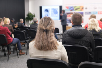 The speaker will speak in the conference room at a business event. Audience in the conference room. Business and entrepreneurship concept. Focus on unrecognizable people in the audience.