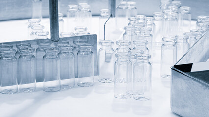 Glass bottles in production in the tray of an automatic liquid dispenser, a line for filling medicines against bacteria and viruses, antibiotics and vaccines.