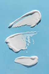 Smears of white cream on a blue background
