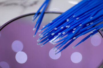 Set of blue microbrushes for eyelashes on a mirror background with bokeh