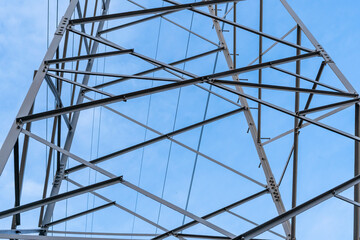 Electric station for supplying electricity to city, village. High voltage electric tower. Close-up. Power line against blue sky. 