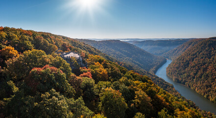 View up the Cheat River in narrow wooded gorge in the autumn with Coopers Rock overlook in the...