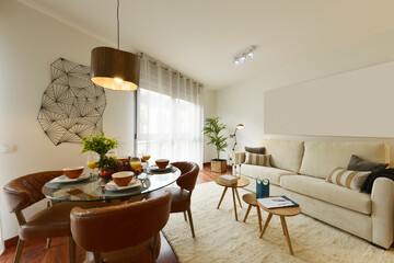 Living room of vacation rental home with round glass dining table with fruit and juice breakfast