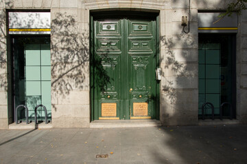 Facades of houses in the city center with green painted wooden doors and granite constructions