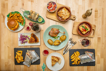 Set of delicious appetizer dishes, tapas, duck confit, lasagna, tarts, burritos in foil and teques with sauce