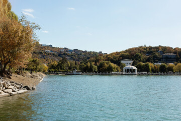 Amazing view of Lake Abrau Durso among the colorful autumn forest. Picturesque wooded mountains and blue sky.